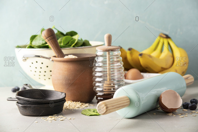 Ingredients for cooking spinach or banana pancakes or baking spinach or banana muffins- oats,  bananas, rolling pin, eggs, spinach, honey