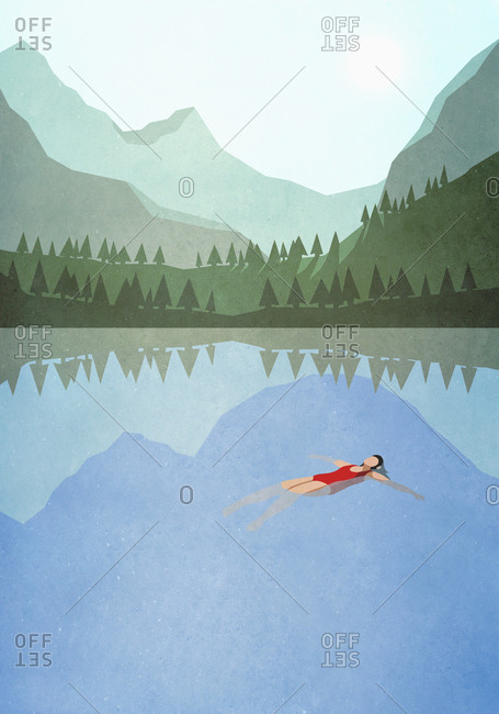 Serene woman floating on back in tranquil mountain lake