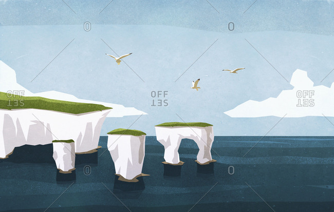 Seagulls flying over ocean rock formations