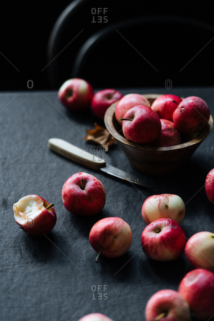Several of red apples and knife on table