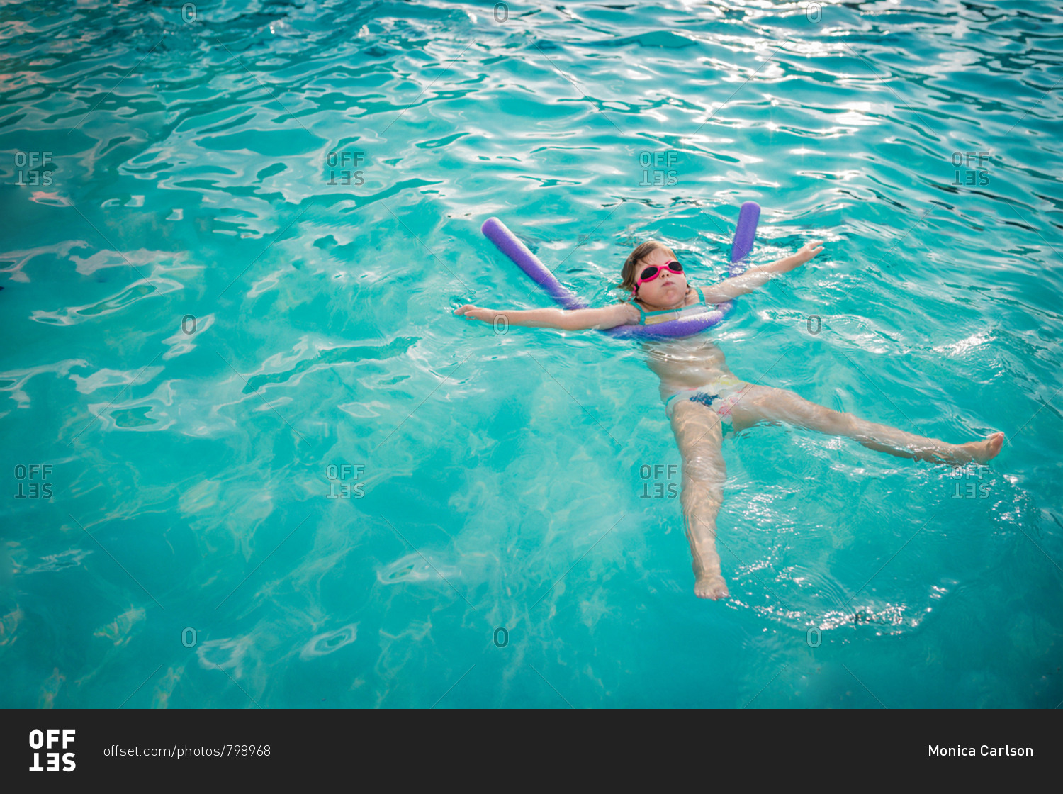 Girl floating in a pool stock photo OFFSET