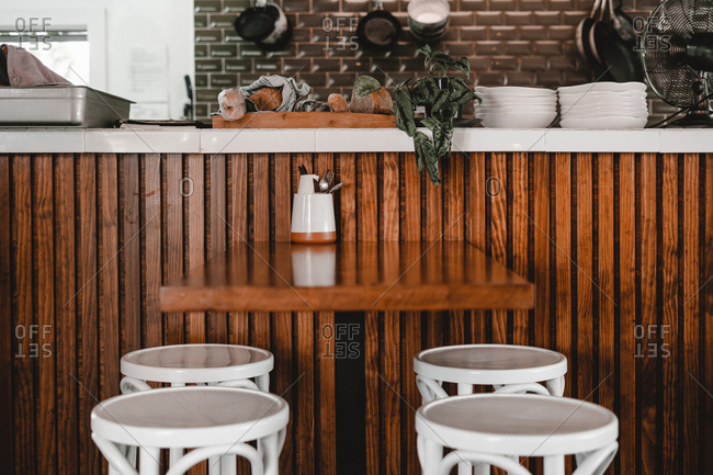 stools near table and wooden bar counter with plates in cafe stock photo offset wooden bar counter with plates in cafe