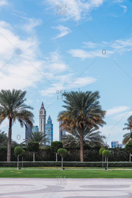 Beautiful view of blue cloudy sky over wonderful city park with exotic palms on sunny day in Dubai