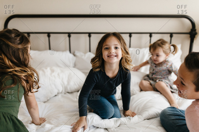 Kids jumping and playing on a bed