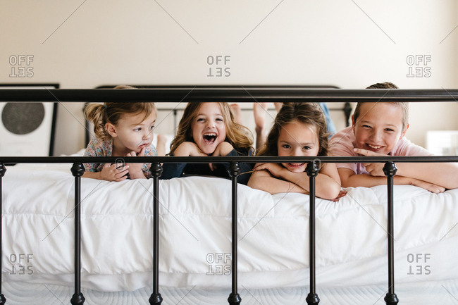 Kids on a bed smiling at the camera