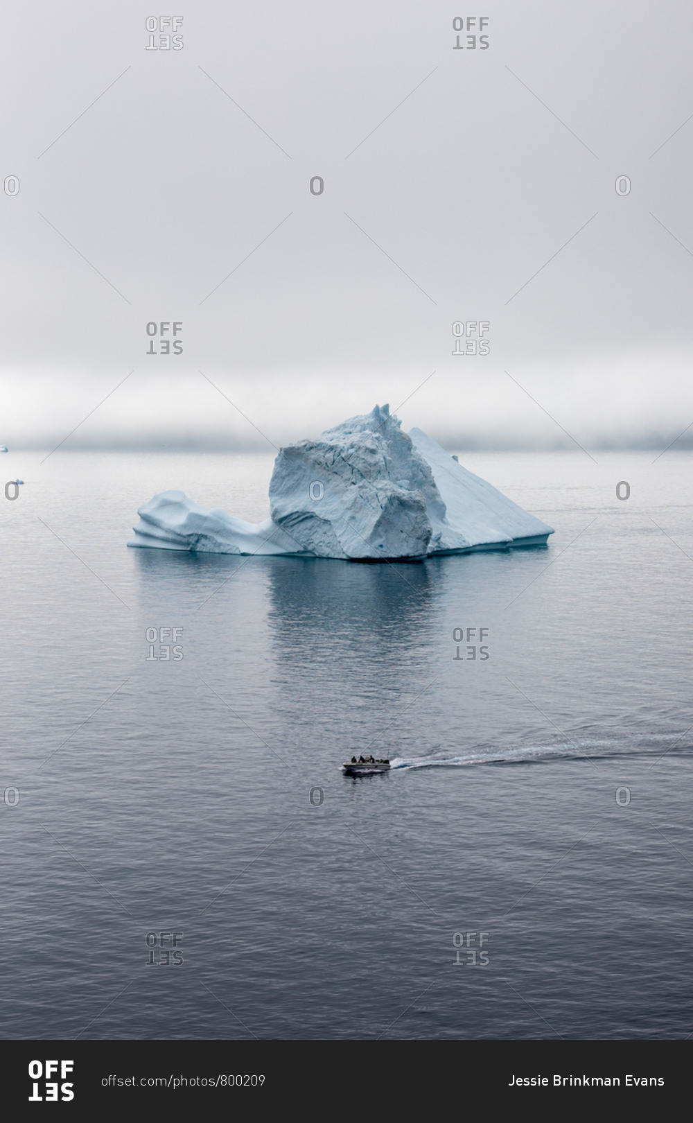 Small boat moving past iceberg in the sea