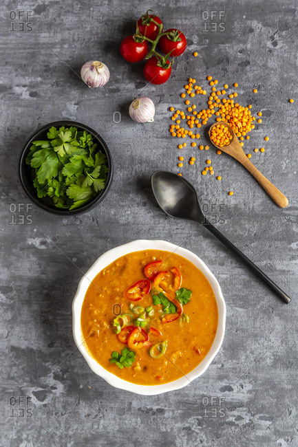 Soup bowl of garnished red lentil soup and ingredients