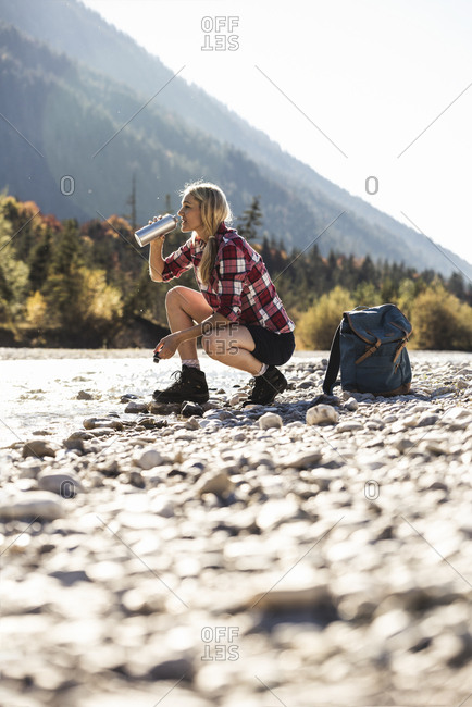 Austria- Alps- woman on a hiking trip having a break at a brook