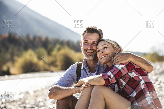 Austria- Alps- happy couple on a hiking trip having a break at a brook