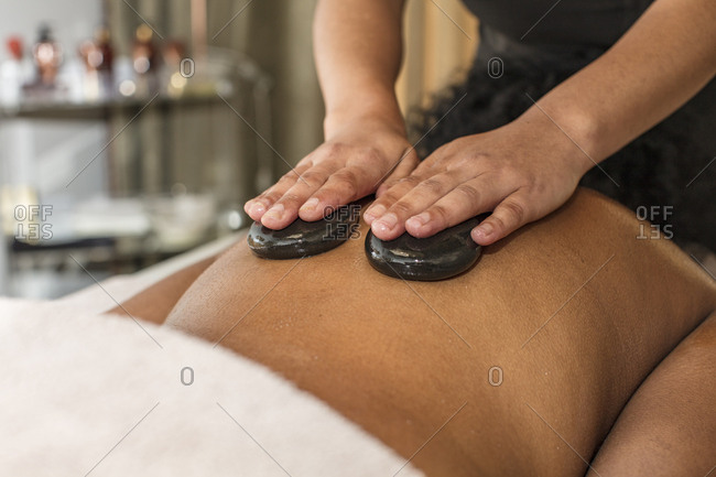 Woman receiving a hot stone massage in a spa