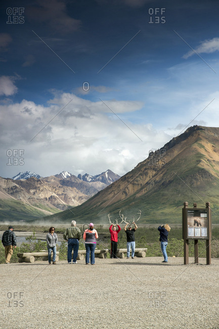 June 29, 2015: USA, Alaska, Denali, Denali National Park, guests pose for photographs during a break on the wildlife viewing drive tour through the park