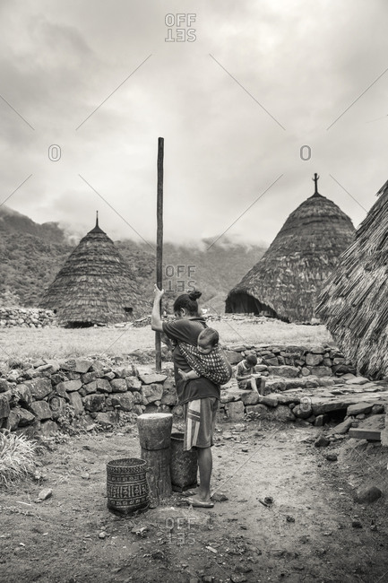 July 20, 2013: INDONESIA, Flores, Rofina Namun and her baby prepare coffee in the mountain village of Wae Rebo