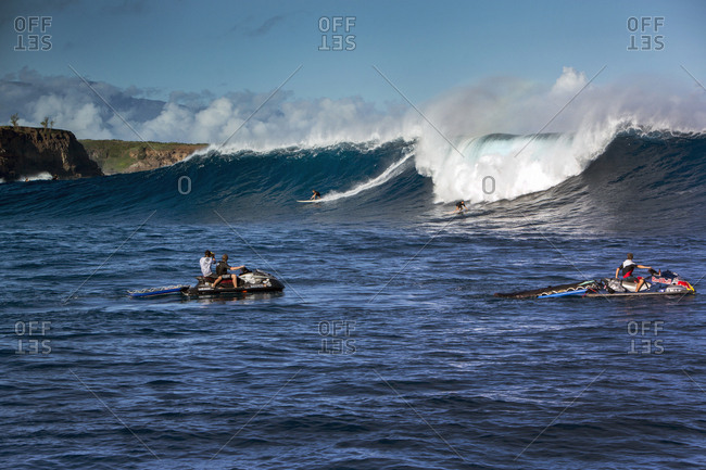 January 17, 2014: USA, HAWAII, Maui, Jaws, big wave surfers taking off on a wave at Peahi on the Northshore