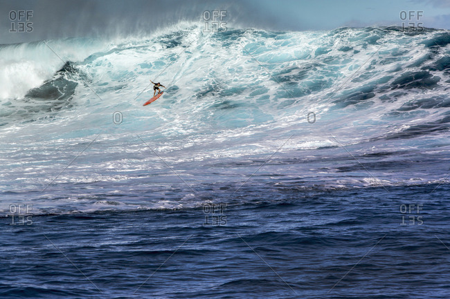January 17, 2014: USA, HAWAII, Maui, Jaws, big wave surfers taking off on a wave at Peahi on the Northshore