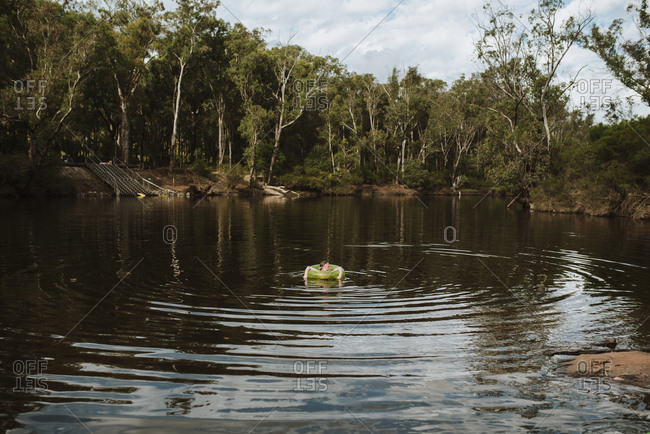 Girl floating on inflatable tube in the river