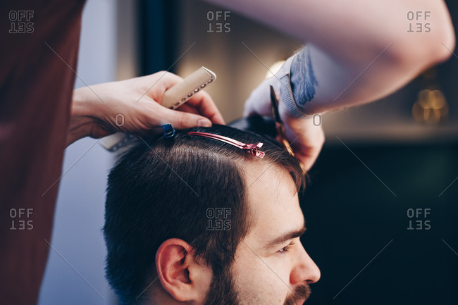 Side View Of Man Getting Modern Haircut At Barber Shop Male