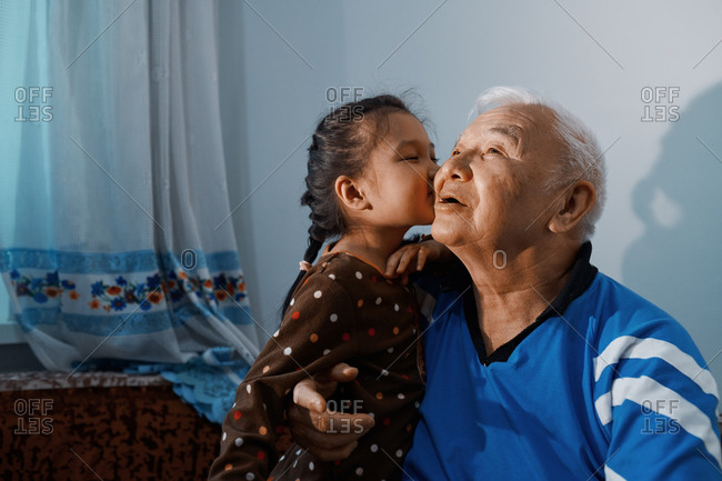 Little girl kissing her grandfather