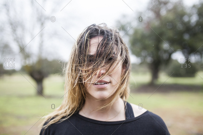 beautiful and young woman training running in the rain on the outskirts of the city