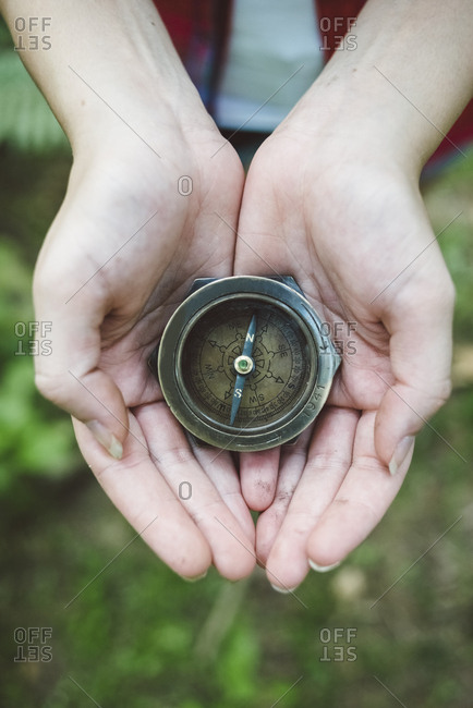 Hands holding an old compass