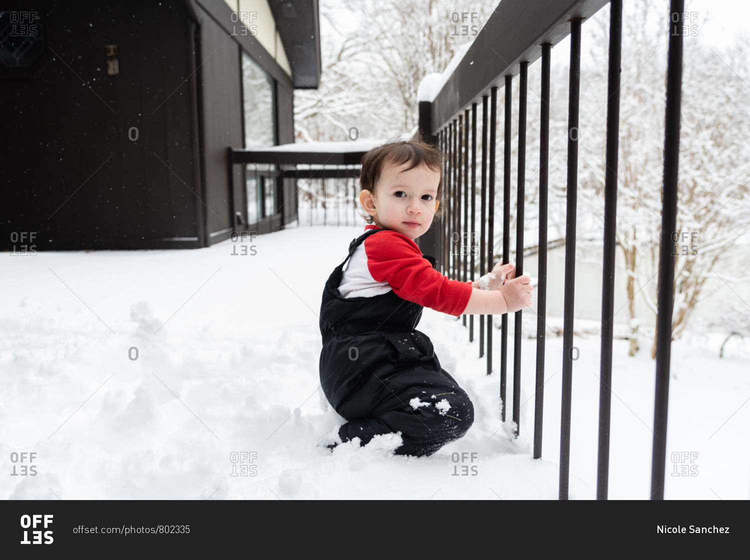 Toddler boy on a snowy deck