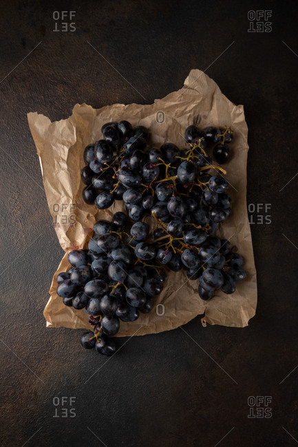Blue grapes on dark metal above