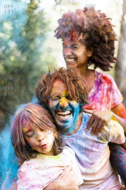 Family full of colorful powder paint- celebrating Holi- Festival of Colors