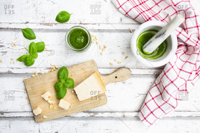 Glass of homemade pesto Genovese- ingredients- mortar and kitchen towel