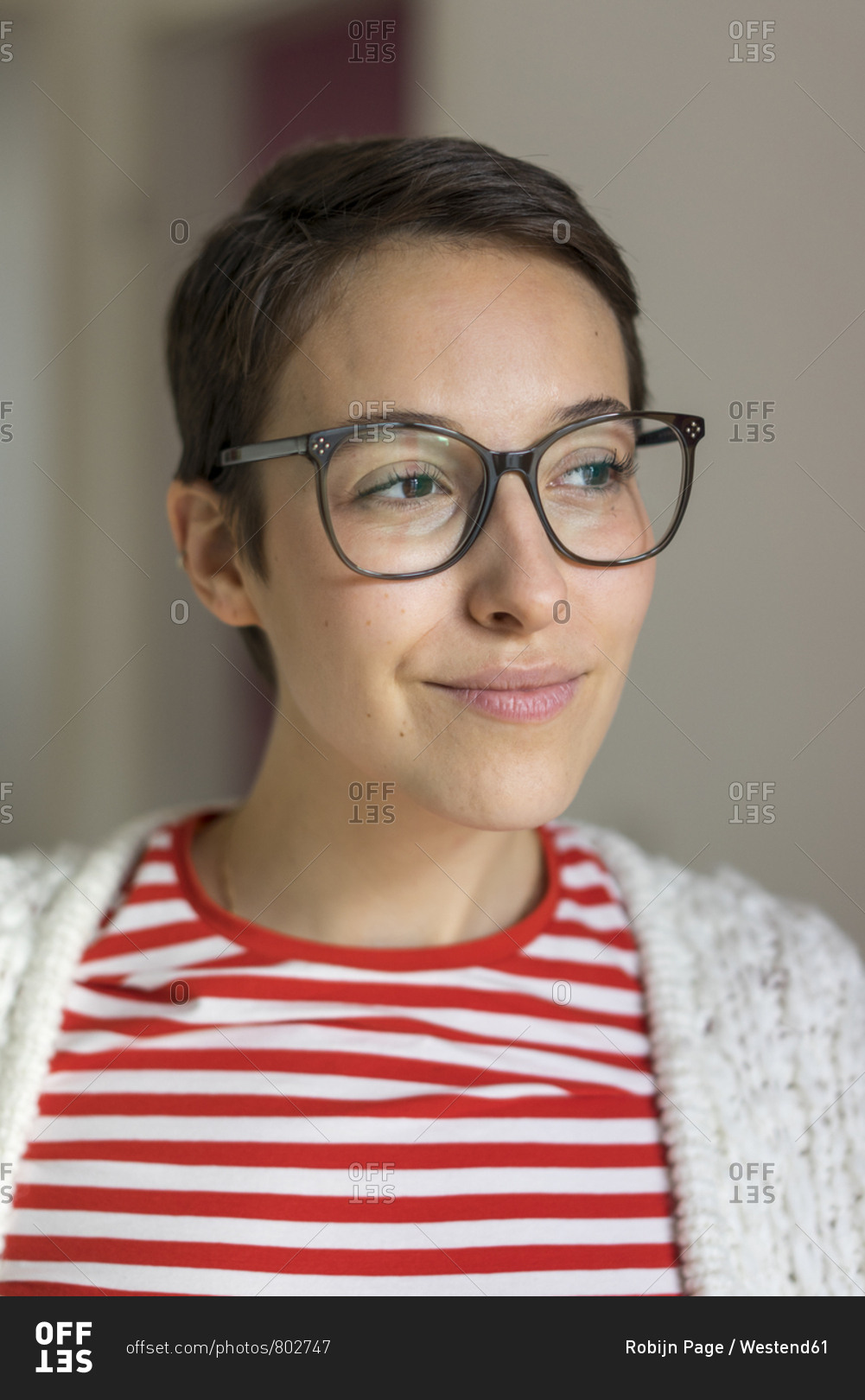 Portrait of a smiling young woman with short hair- wearing glasses stock  photo - OFFSET