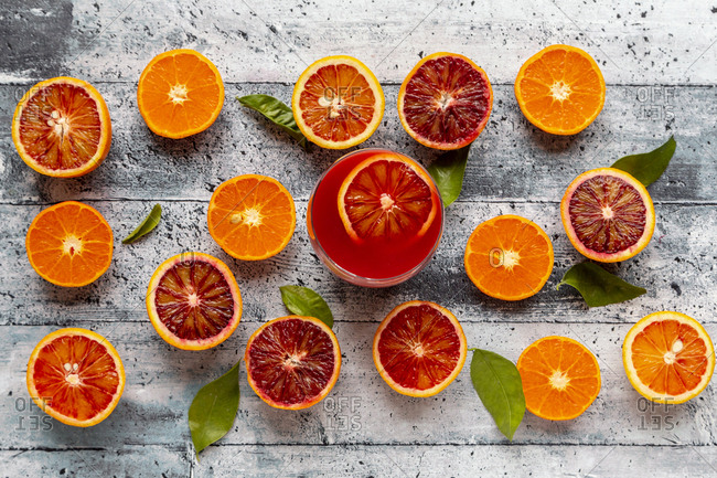 Halves of blood oranges- tangerines and glass of blood orange juice