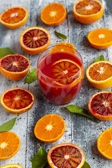 Halves of blood oranges- tangerines and glass of blood orange juice