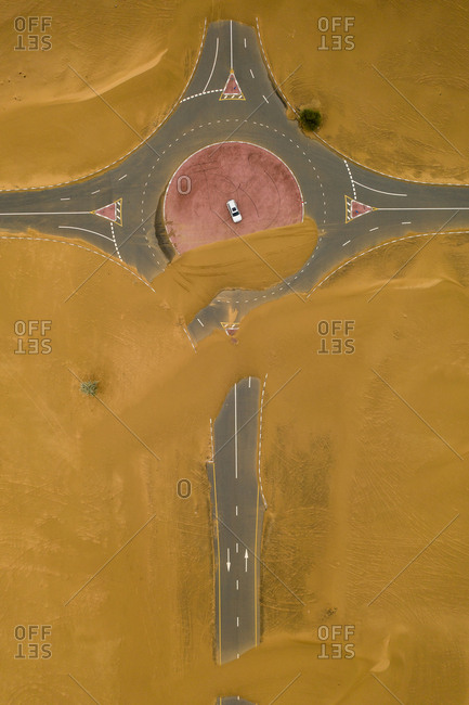 Wind blown sand covering highway and traffic circle in the desert