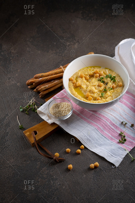 Bowl of hummus on a wooden board