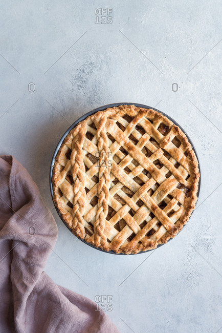 Full fresh pie in a tin with a napkin by its side.