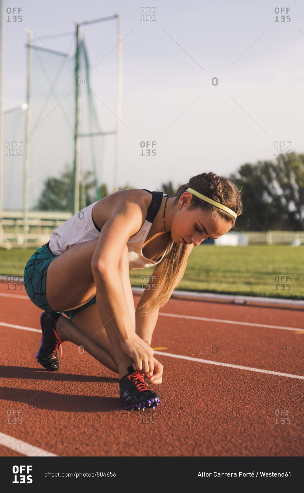 Female athlete tying shoe laces on tartan track