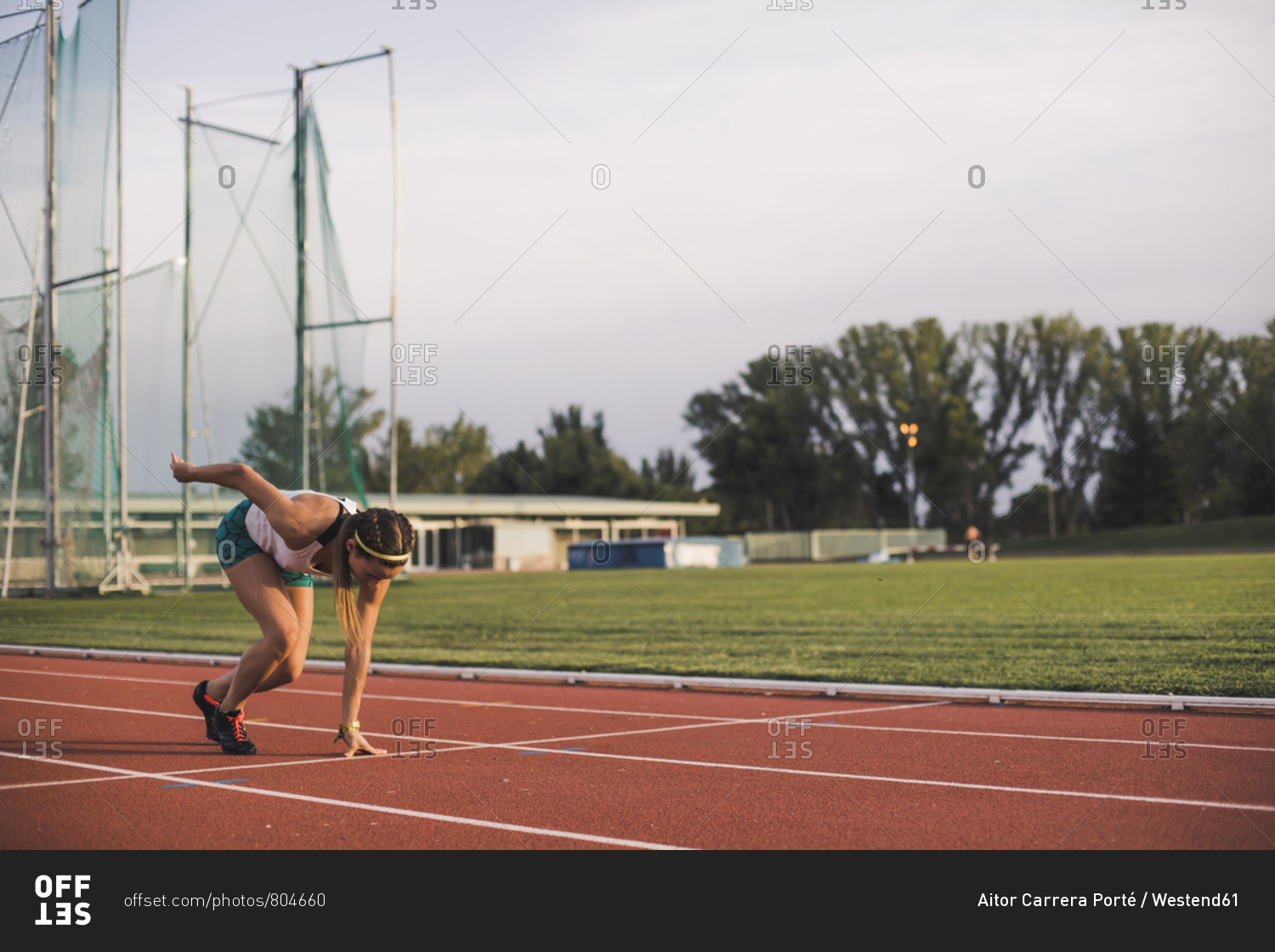 Female runner on tartan track starting