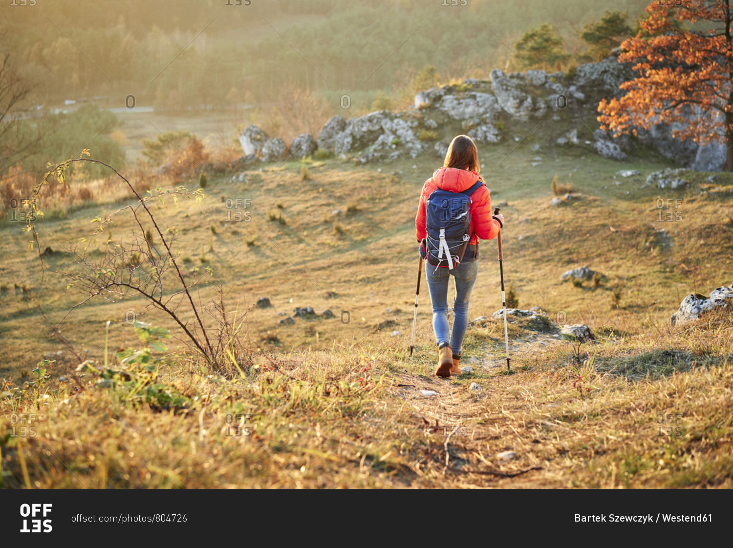 Rear view of woman walking on trail on a hiking trip in the mountains