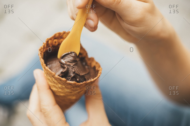 Woman's hand holding ice cream cone with chocolate ice- close-up