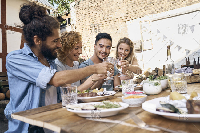 Friends having fun at a barbecue party- eating together