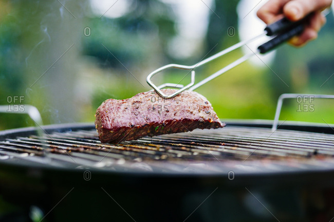 Grilling lamb fillet on charcoal grill