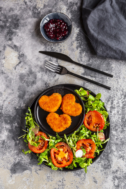 Baked camembert in heart shape with rocket- lamb's lettuce- tomato- radish and lingonberry