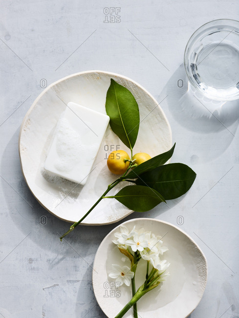 Homeopathic soap on a plate with lemon near a glass of water.