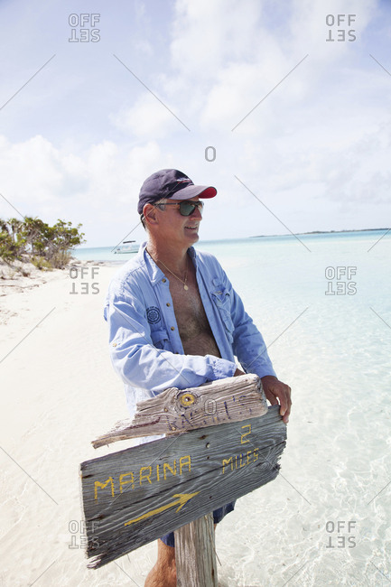 October 28, 2011: EXUMA, Bahamas. Yves, holding up a sign on Compass Cay.