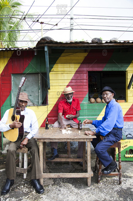 January 31, 2012: JAMAICA, Port Antonio. Albert Minott, Joseph "Powder" Bennett and Derrick "Johnny" Henry of the Mento band, The Jolly Boys playing dominoes at the Willow Wind Bar.