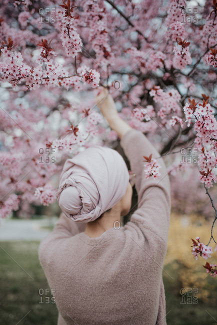 Woman holds branch of cherry blossoms