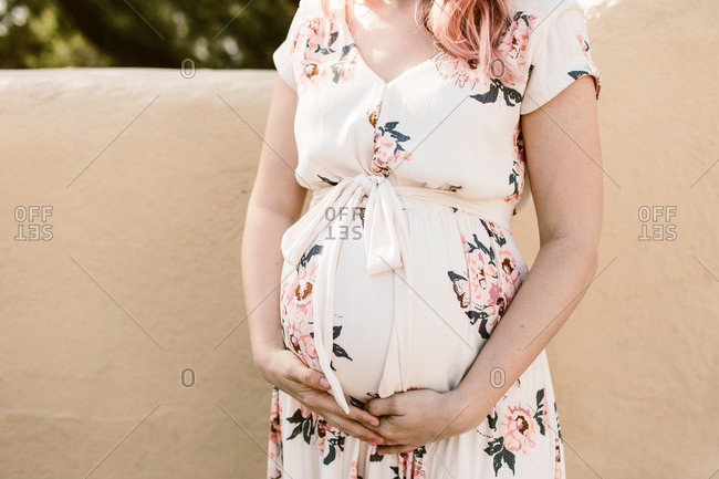 Maternity photo of pregnant woman holding her belly