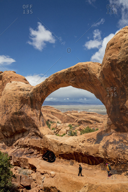 United States, Utah, Arches National Park, Tourist walking on the Double O Arch along the Devils Garden Loop in the Arches park