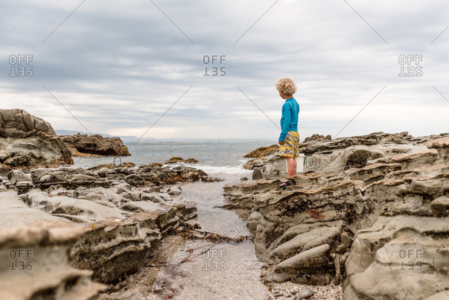 Young boy observing water and rock formations