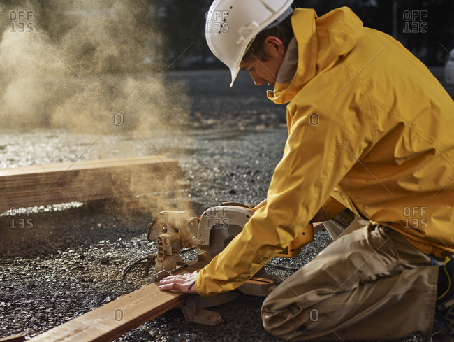 Man sawing decking board with circular saw