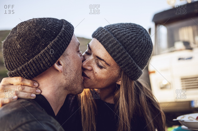 Kissing couple wearing wooly hats