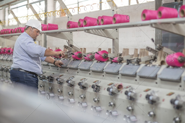 Man working with spools in factory
